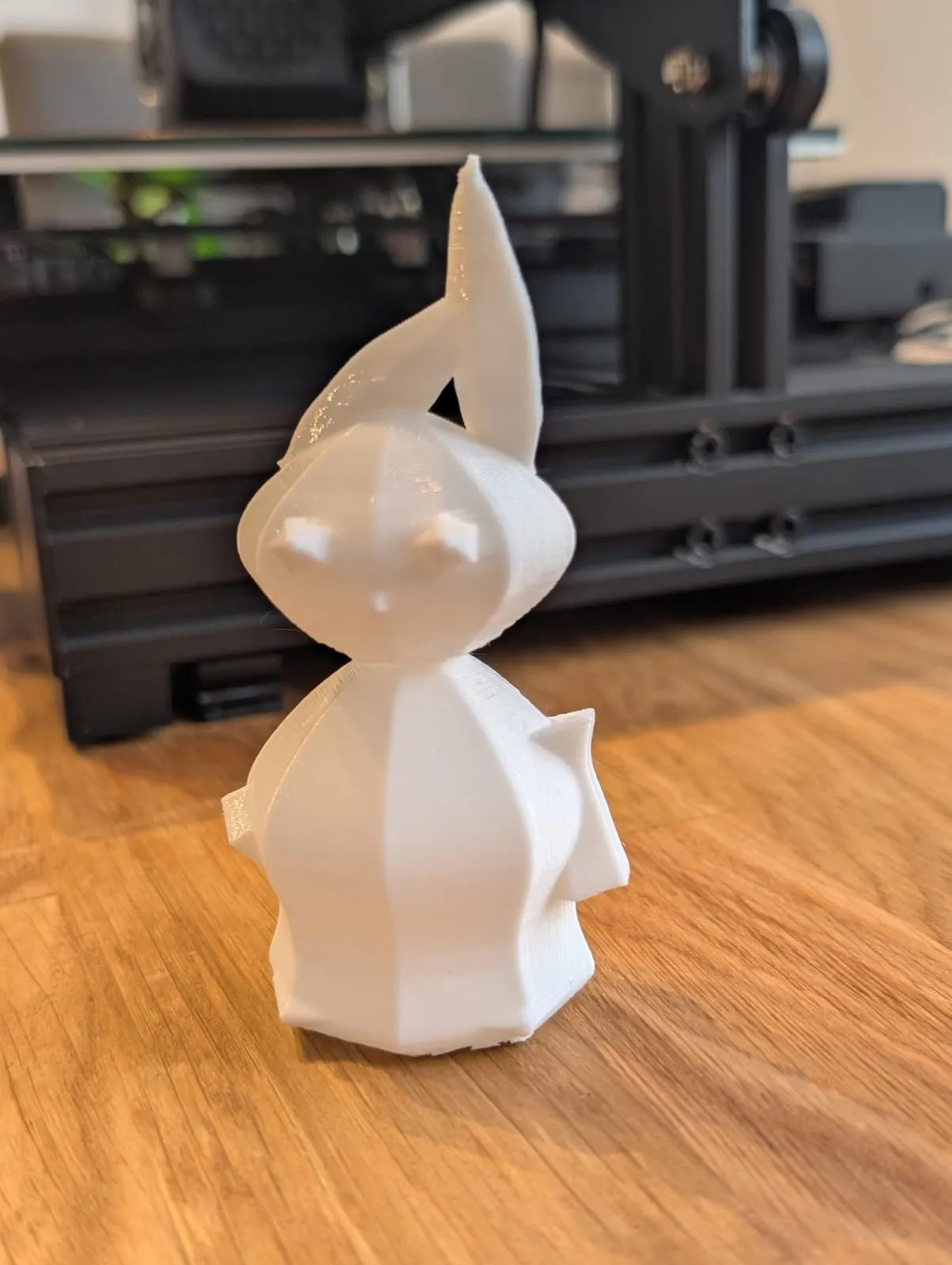 The finished 3D-printed bunny on the desk next to the Ender 3 printer